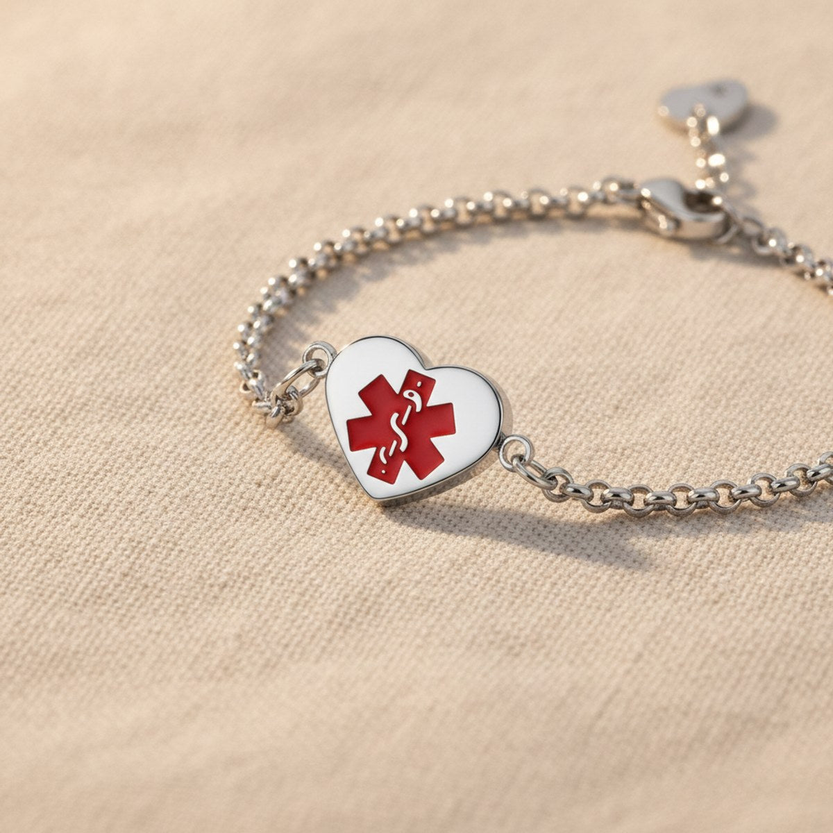 Heart charm with red Star of Life medical symbol on steel bracelet chain, lifestyle macro photo
